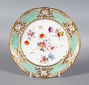 A NANTGARW PORCELAIN PLATE 8.25ins diameter, with gilt border, the centre painted with flowers